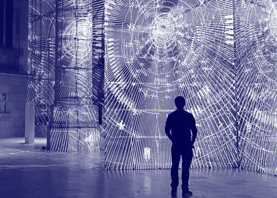Zdjęcie przedstawia mężczyznę stojącego przed instalacją wizualną | The picture shows a man standing in front of a visual installation