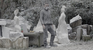 Mężczyzna w masce, wśród marmurowych rzeźb. Cała sceneria przyprószona białym pyłem. | The man in the mask among the marble sculptures. The whole scenery is dusty with white dust.