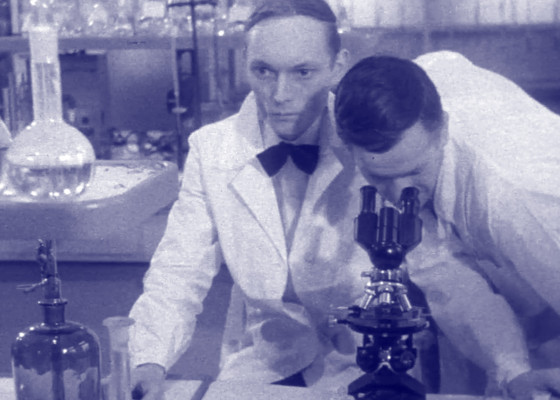 Profesor Foss i jego asystent badający próbkę pod mikroskopem. | Professor Foss and his assistant examining the sample under the microscope.