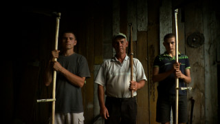 Portret kosynierów: ojciec i dwóch synów z kosami w stodole. | Portrait of blackbirds: father and two sons with scythes in the barn.