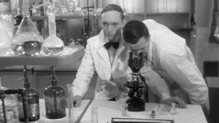 Profesor Foss i jego asystent badający próbkę pod mikroskopem. | Professor Foss and his assistant examining the sample under the microscope.