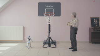 Starsza kobieta grająca z robotem w koszykówkę. | Elderly woman playing basketball with a robot.