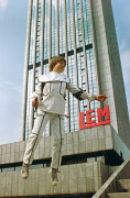 Chłopiec latający po Warszawie na tle wieżowca. | A boy flying around Warsaw against the backdrop of a skyscraper.