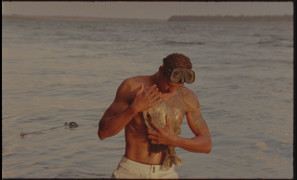 Zdjęcie przedstawia rybaka obejmującego złowioną rybę. | The photo shows a fisherman hugging a caught fish.